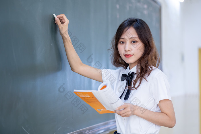 黑板前拿粉笔写字的女生