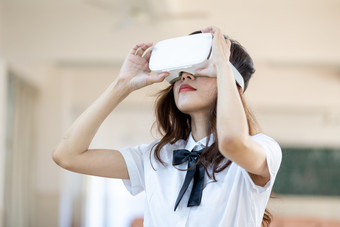 青年女性戴<strong>VR</strong>眼镜体验虚拟现实游戏场景