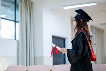 穿着学士服拿毕业证书的学生