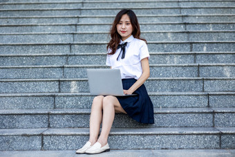 校园里的女大学生学习阅读读书写作业