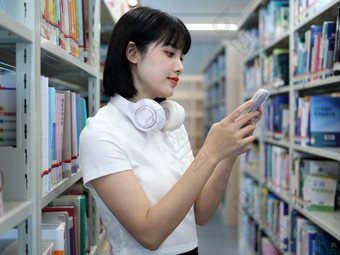 <strong>图书馆看书</strong>的女大学生学习阅读书写作业