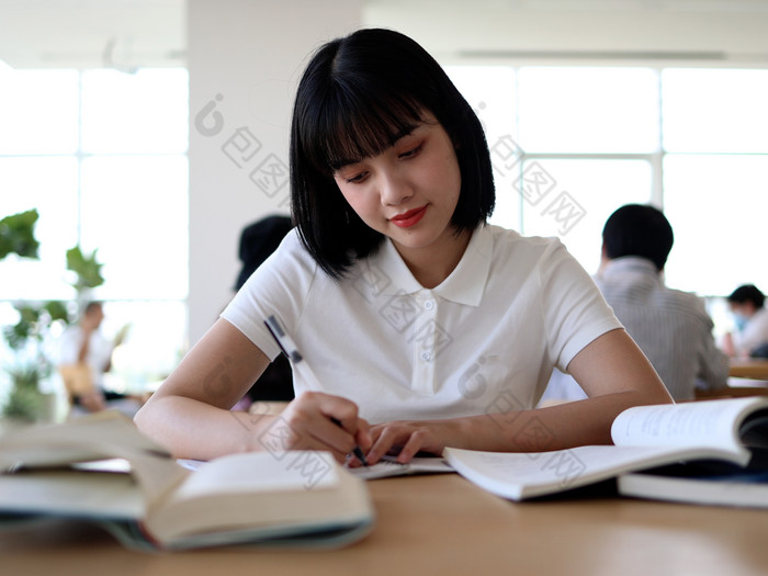 图书馆看书的女大学生学习阅读书写作业