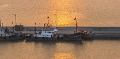 夕阳海上渔船摄影图