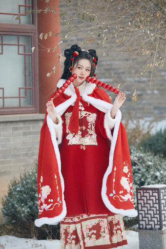 雪天户外身穿中式红色汉服的亚洲少女