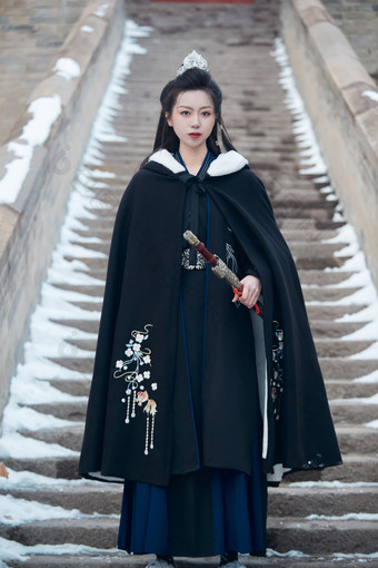 雪天古城身穿汉服扮演武侠的中国少女