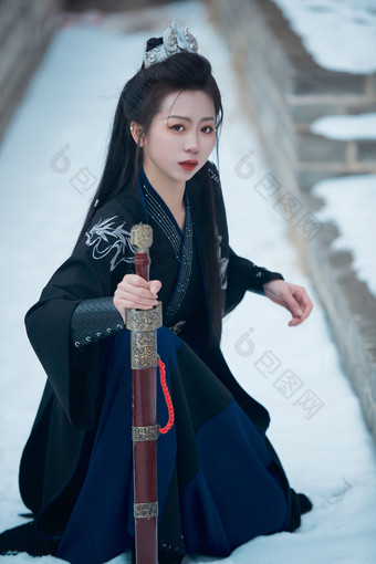 雪天古城身穿汉服扮演武侠的中国少女