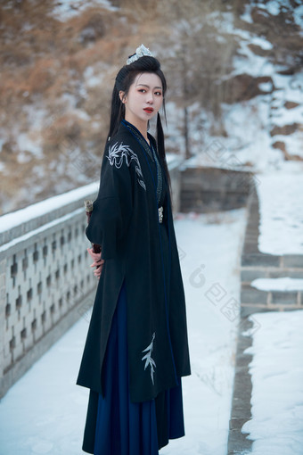 雪天古城身穿汉服扮演武侠的中国少女