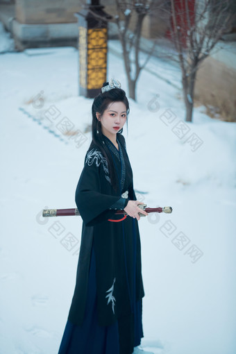 雪天古城身穿汉服扮演武侠的中国少女