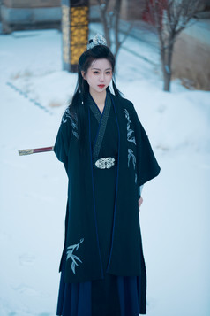 雪天古城身穿汉服扮演武侠的中国少女