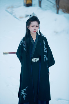 雪天古城身穿汉服扮演武侠的中国少女