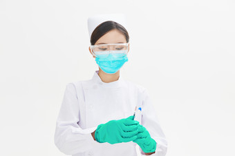 穿护士服戴口罩手执针筒的年轻女护士图片