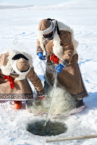 寒冷的<strong>冬季</strong>在冰冻的湖面上凿冰捕鱼的人们