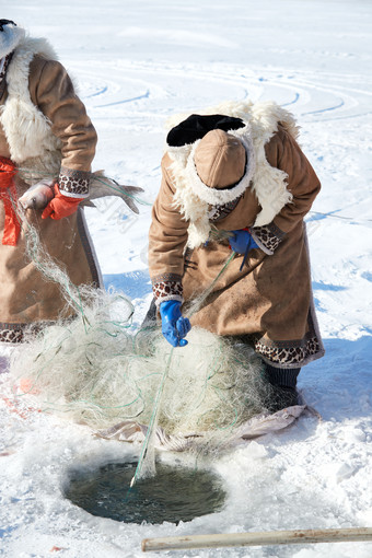 寒冷的<strong>冬季</strong>在冰冻的湖面上凿冰捕鱼的人们