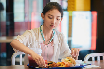 在商场快餐厅大吃特吃的中国可爱少女人像