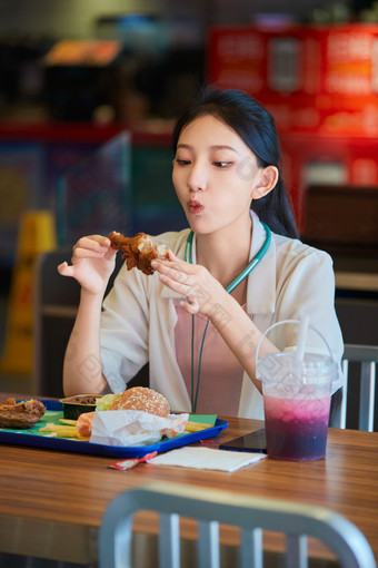 在商场<strong>快餐厅</strong>大吃特吃的中国可爱少女人像