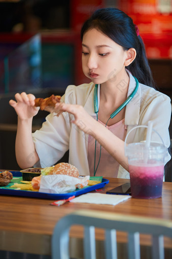 在商场快餐厅大吃特吃的中国可爱少女人像