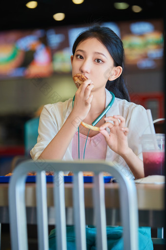 在商场<strong>快餐厅</strong>大吃特吃的中国可爱少女人像