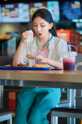 在商场快餐厅大吃特吃的中国可爱少女人像