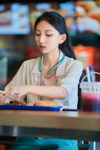 在商场快餐厅大吃特吃的中国可爱少女人像