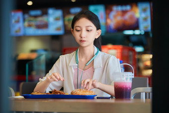 在商场快餐厅大吃特吃的中国可爱少女人像