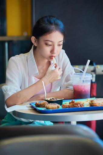 在商场快餐厅大吃特吃的中国可爱少女人像