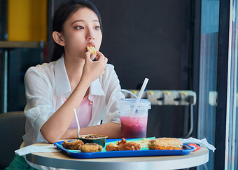 在商场快餐厅大吃特吃的中国可爱少女人像