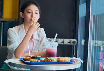 在商场快餐厅大吃特吃的中国可爱少女人像