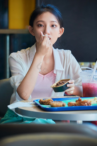 在商场快餐厅大吃特吃的中国可爱少女人像