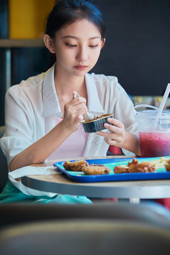 在商场快餐厅大吃特吃的中国可爱少女人像