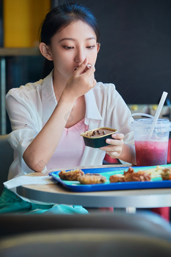 在商场快餐厅大吃特吃的中国可爱少女人像