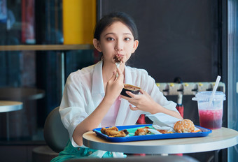 在商场快餐厅大吃特吃的中国可爱少女人像