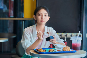 在商场快餐厅大吃特吃的中国可爱少女人像