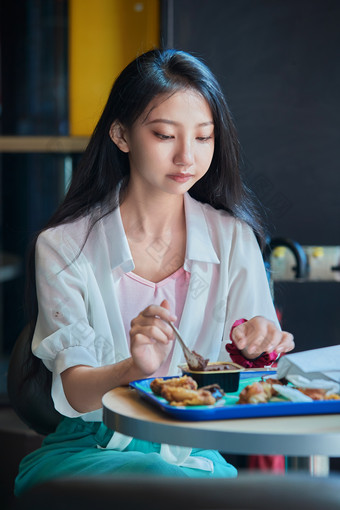 在商场<strong>快餐厅</strong>大吃特吃的中国可爱少女人像