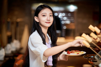 在<strong>星级</strong>酒店自助<strong>餐厅</strong>用餐的可爱中国少女