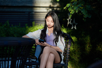 <strong>夕阳</strong>下在庭院休息拍照的亚洲少女