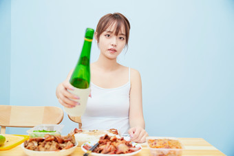 在餐桌前<strong>吃</strong>午餐喝白酒的亚洲少女