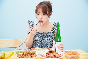 在餐桌前<strong>吃</strong>午餐喝白酒的亚洲少女