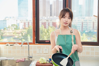 在厨房<strong>下厨</strong>做饭的年轻亚洲女性