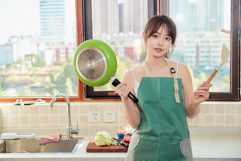 在厨房下厨做饭的年轻亚洲女性