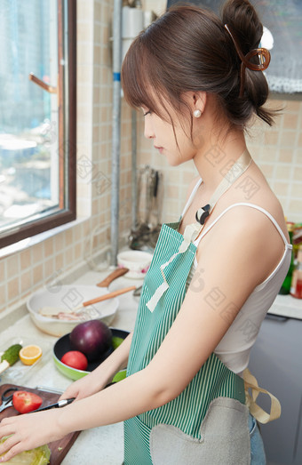 在厨房下厨做饭的年轻亚洲女性