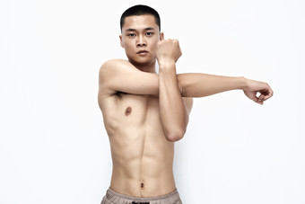 白色背景下展示健身预备<strong>拉伸动作</strong>的亚洲男性