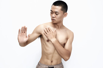 白色背景下展示健身预备拉伸动作的亚洲男性