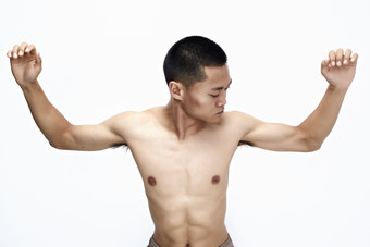 白色背景下展示健身预备拉伸动作的亚洲男性