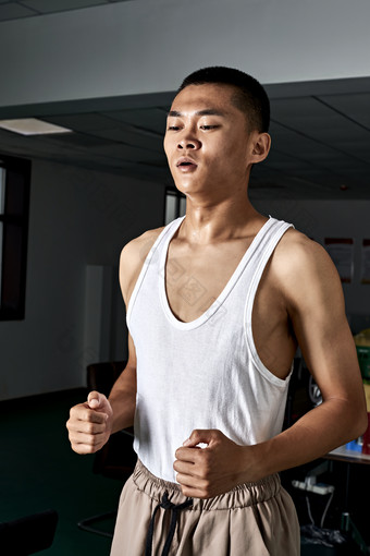 在室内用跑步机进行锻炼的亚洲健身男士形象
