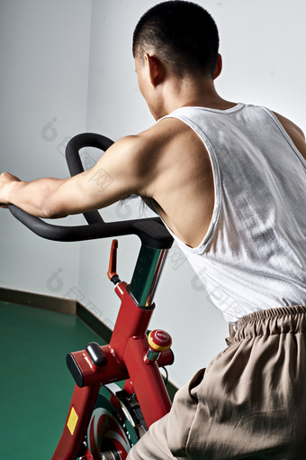 在室内进行动感<strong>单车</strong>锻炼的亚洲健身男士形象