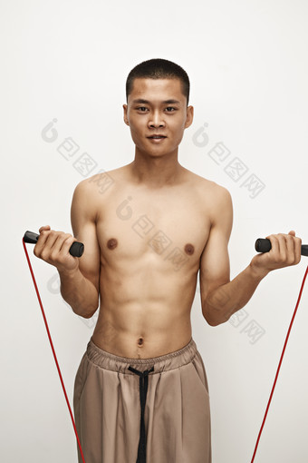 白色背景下手持运动跳绳的亚洲健身男士形象