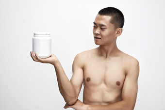 手持蛋白粉的身材匀称肌肉扎实的亚洲男性