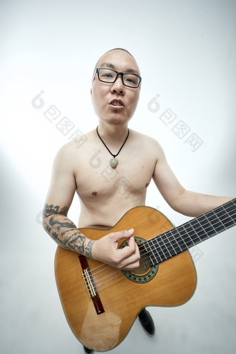 示范演奏古典吉他的亚洲男性乐手人像