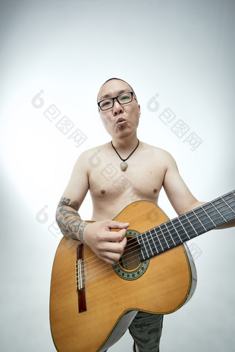示范演奏古典吉他的亚洲男性<strong>乐手</strong>人像
