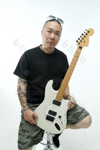 手持电吉他展示演奏的亚洲男性摇滚乐手人像